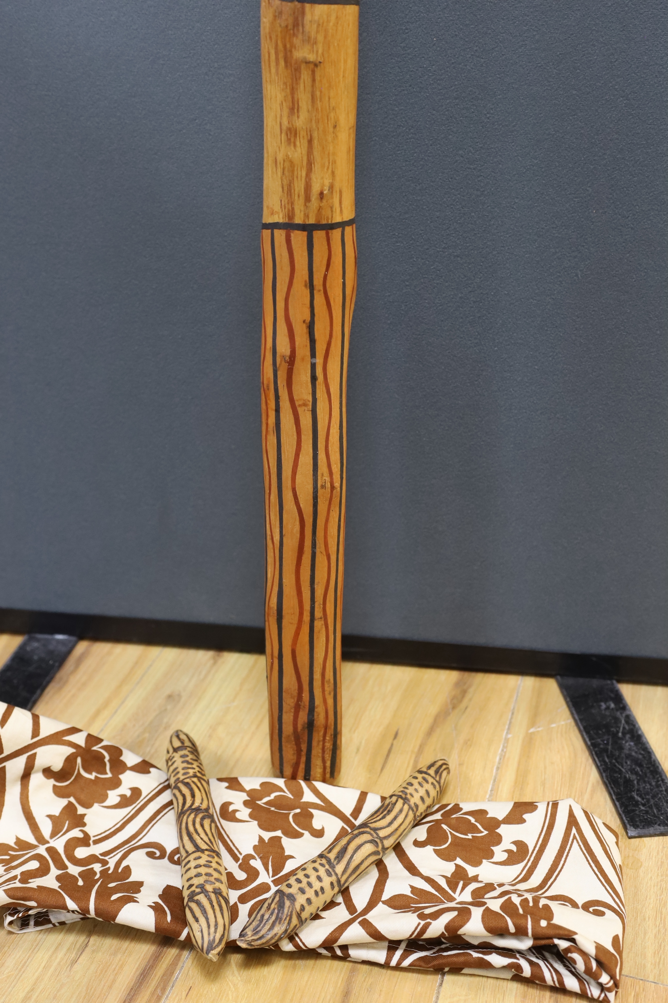 An Aboriginal decorated didgeridoo, Walpari tribe oil on canvas, a fabric painted panel and two decorated wooden sticks, canvas 50x61cm